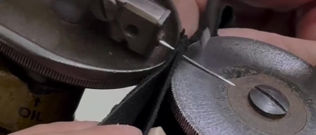 En el taller: la mesa de corte con las chavetas, la máquina de rebajar, el cuero cortándose a mano y la máquina de coser guantes.