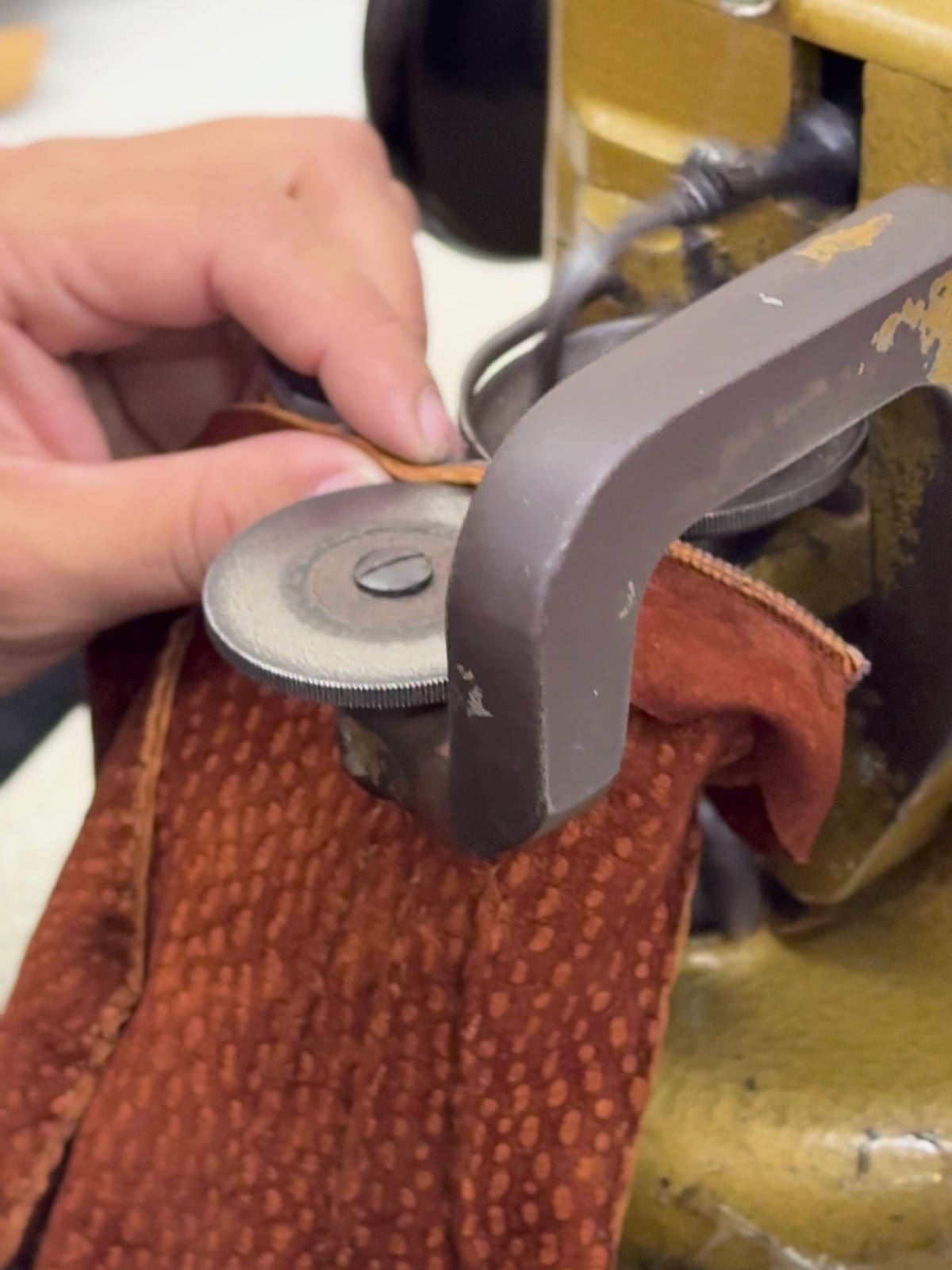 Un guante de carpincho cosiéndose en la máquina del taller